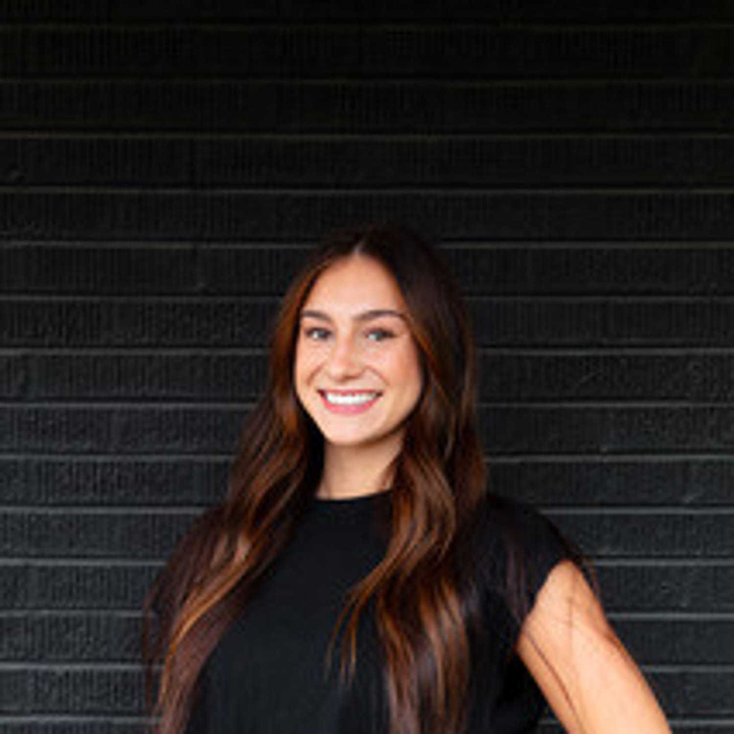 Portrait of Delaney, a professional stylist at Style Bar Salon, showcasing their expertise and style.