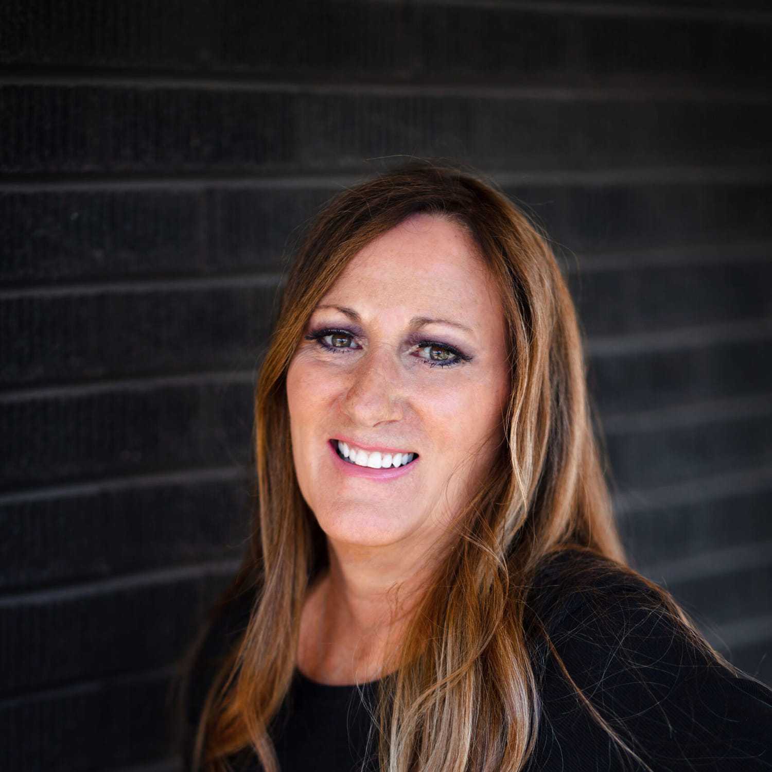 Portrait of Dena Tarkalson, a professional stylist at Style Bar Salon, showcasing their expertise and style.