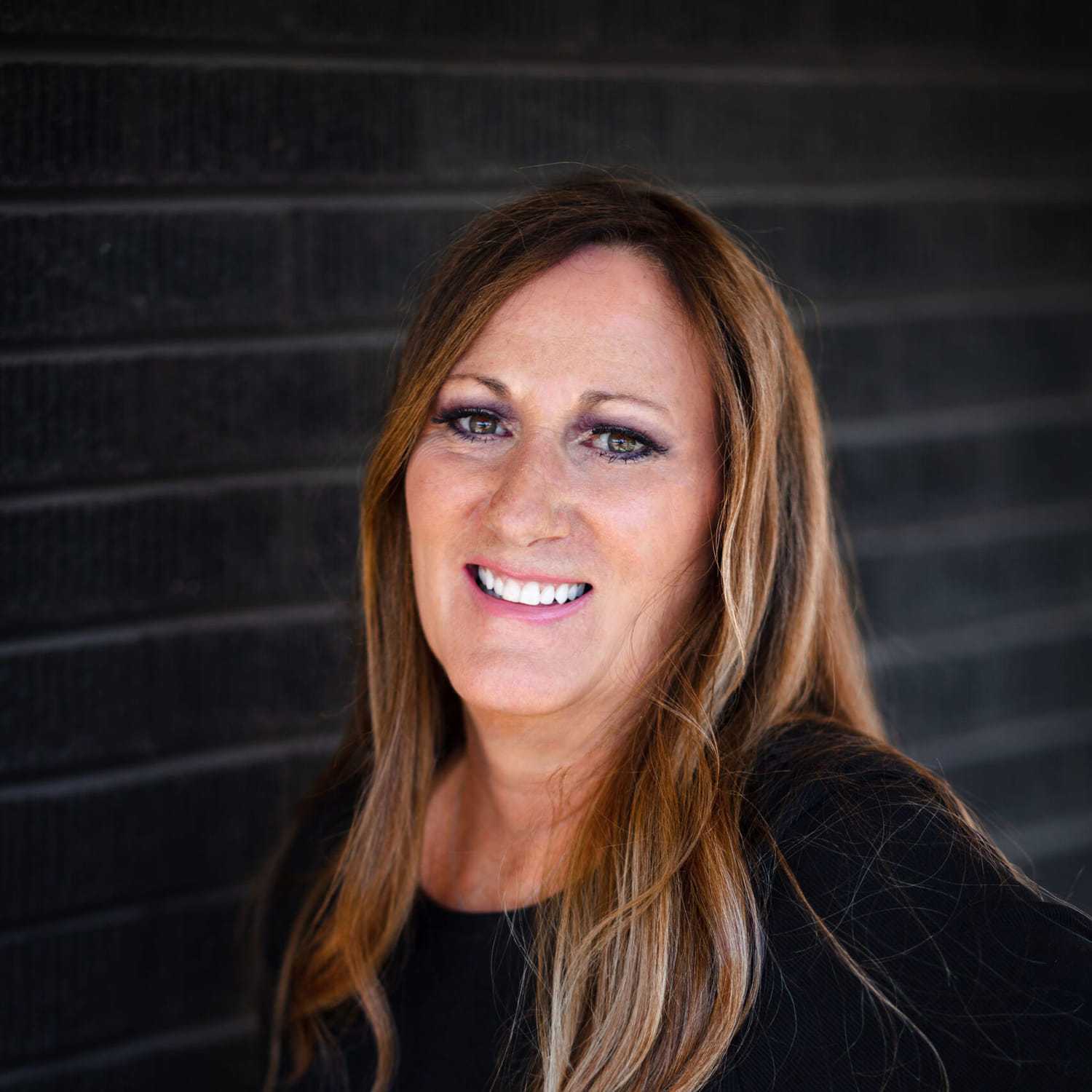 Portrait of Dena Tarkalson, a professional stylist at Style Bar Salon, showcasing their expertise and style.